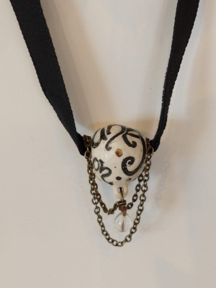necklace with a sleeping face on a velvet ribbon by ursula aavasalu tigukass