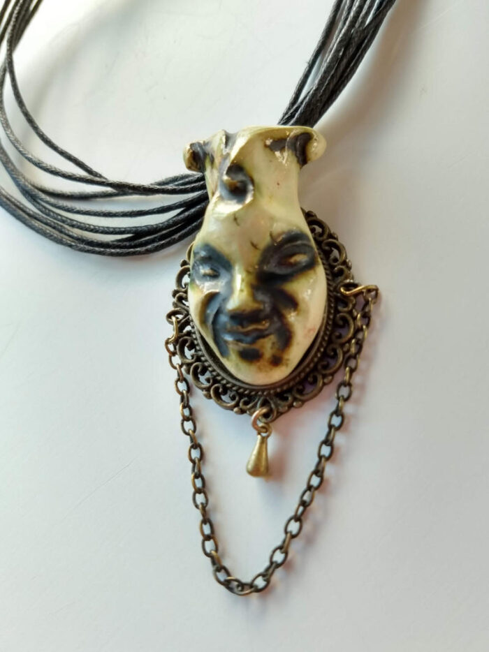 pendant with a joker face by ursula aavasalu tigukass