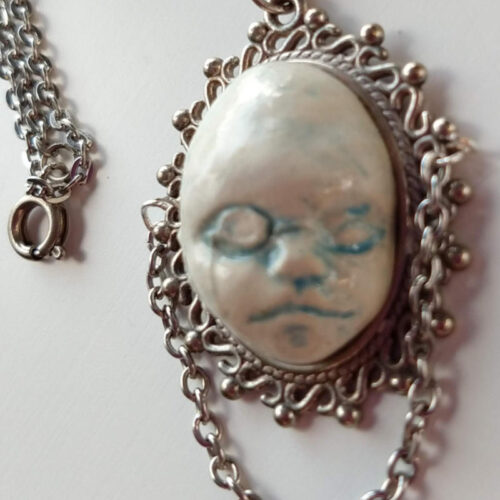 pendant with a sleeping face by ursula aavasalu tigukass