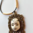 pendant with a thoughtful face by ursula aavasalu tigukass